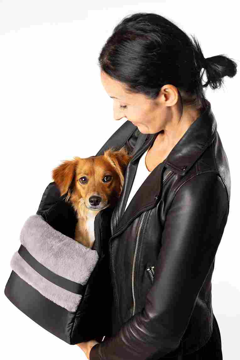 Woman carrying her small dog inside lollypup pet carrier tote
